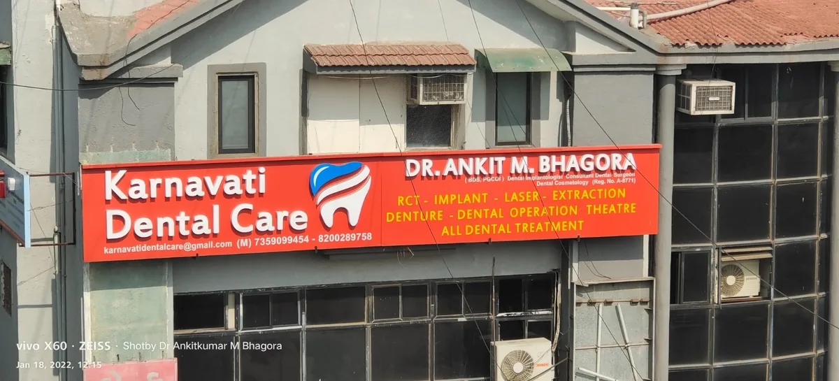 The Karnavati Dental Care signboard listing the clinic's dental services in Vastrapur, Ahmedabad